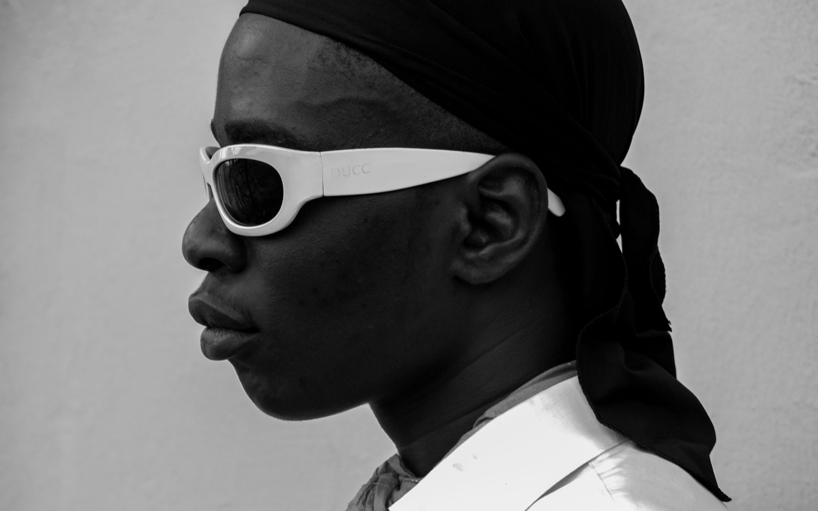 Portrait en noir et blanc d'un homme portant des lunettes de soleil blanches
